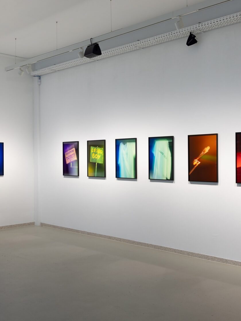 Ausstellung mit Fotografien von Aura und Mario Kiesenhofer, farbenfrohe Kunstwerke an der Wand.