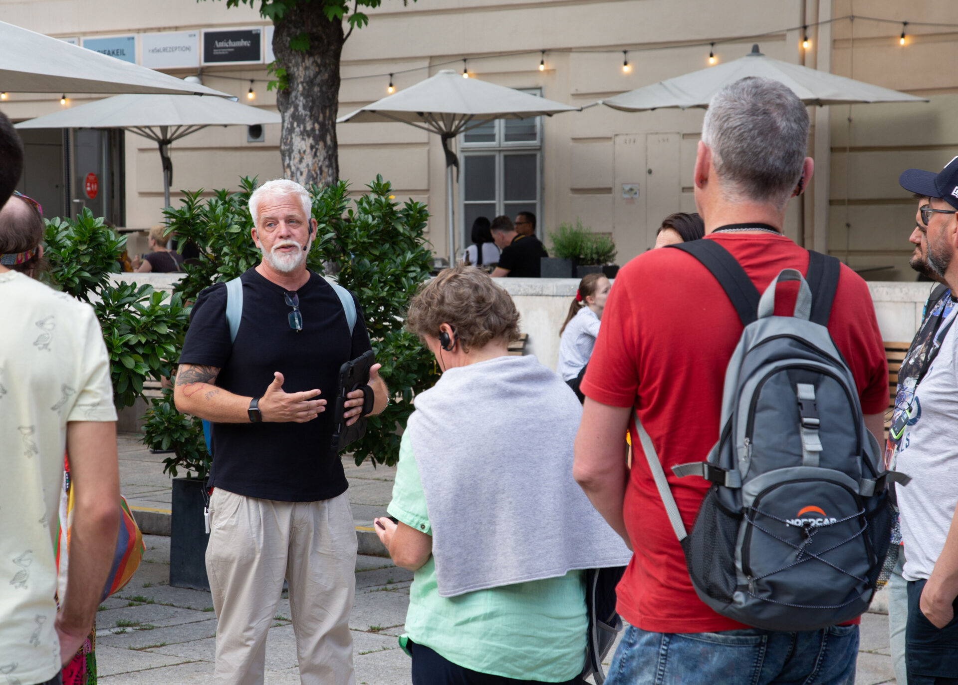 A group of people listening to a speaker during an outdoor discussion event.